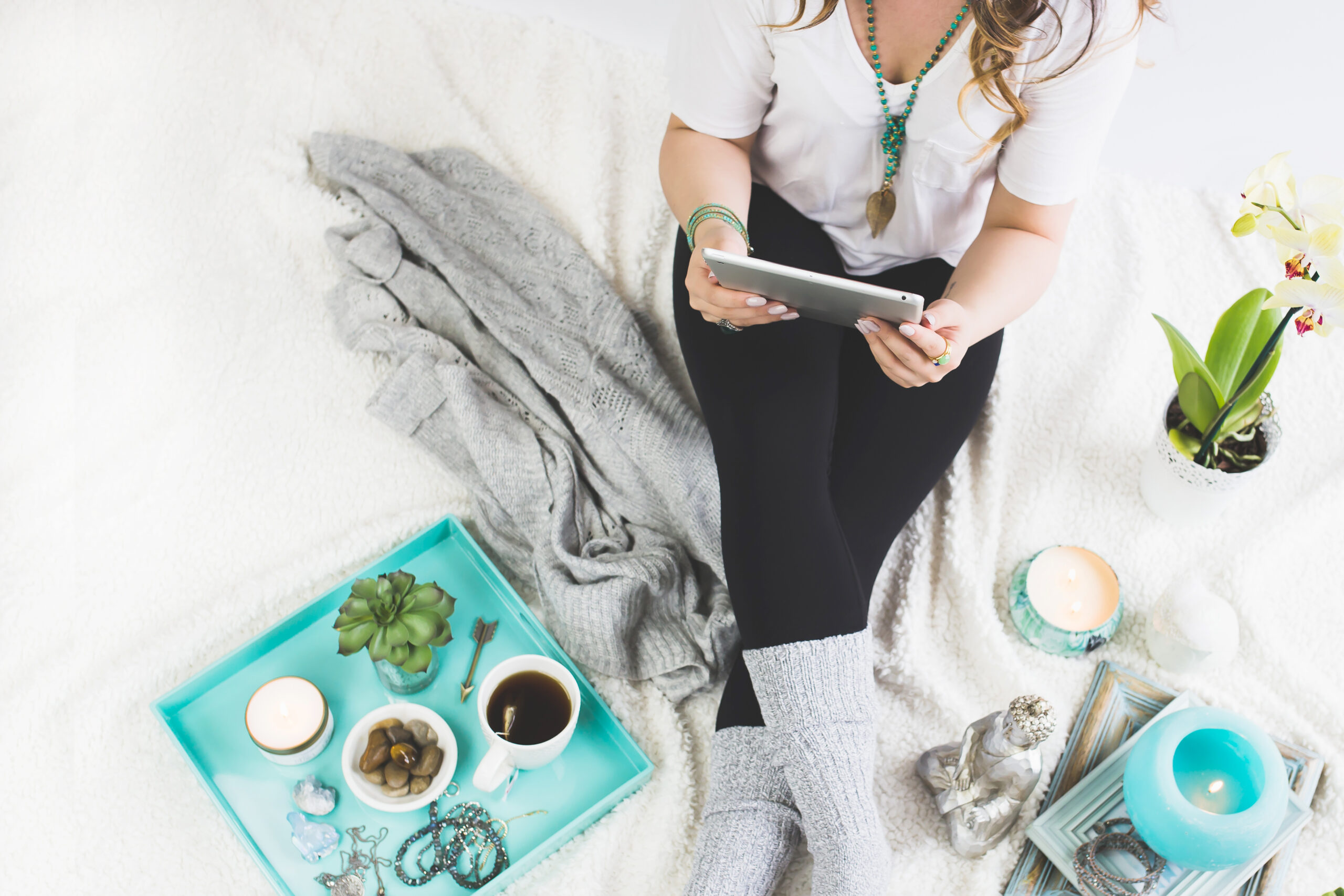 Woman sitting on floor with candles and tea